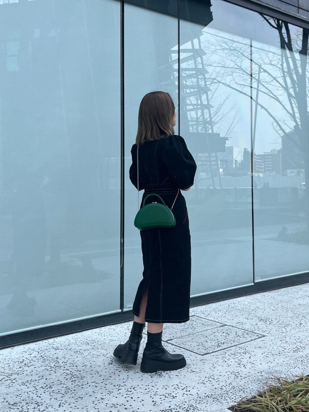 ブラック系のワンピースを着用したレディースの春コーディネートの2枚目の写真