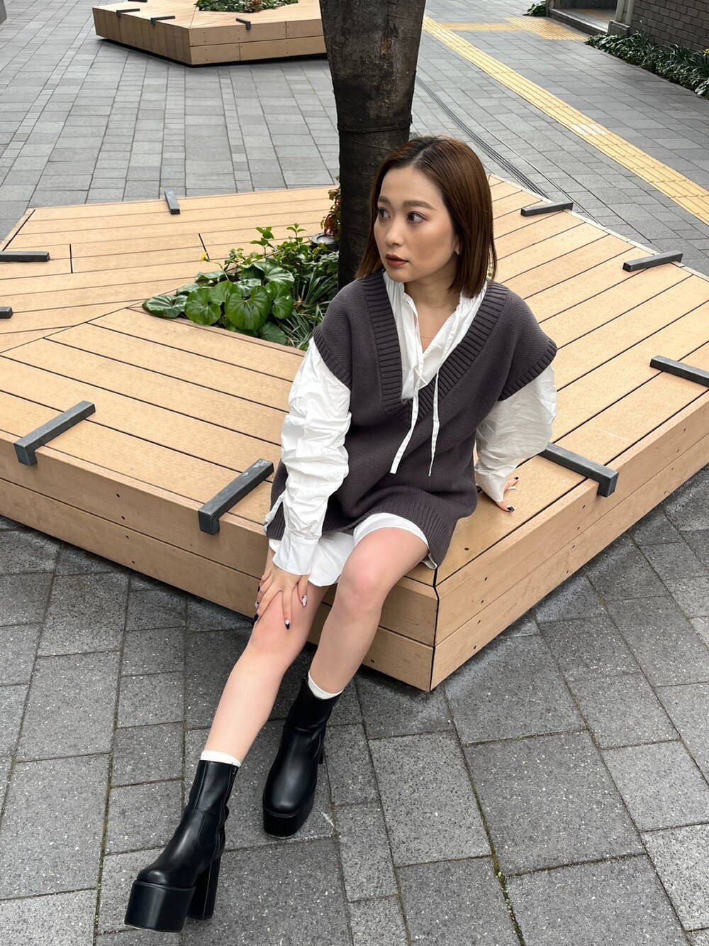 ホワイト系のシャツ/ブラウス、グレー系のベスト、ブラック系のブーツを着用したレディースの冬コーディネートの2枚目の写真