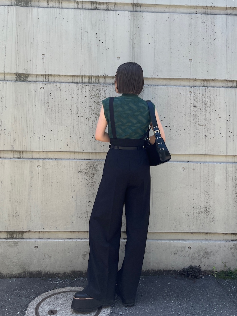 グリーン系のニット/セーター、ブラック系のその他パンツ、ブラック系のブーツを着用したレディースの夏コーディネートの2枚目の写真