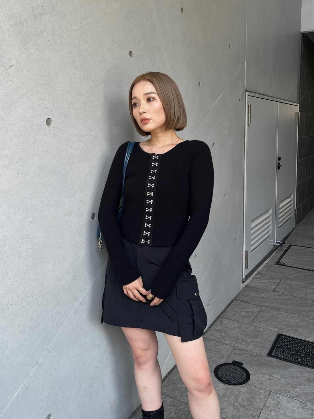 ブラック系のブーツ、ブラック系のスカート、ブラック系のニット/セーターを着用したレディースの夏コーディネートの4枚目の写真