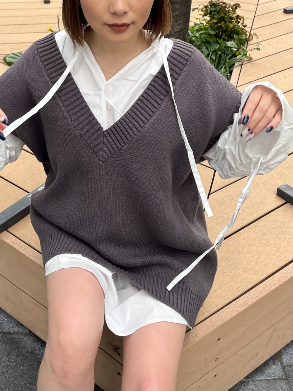 ホワイト系のシャツ/ブラウス、グレー系のベスト、ブラック系のブーツを着用したレディースの冬コーディネートの4枚目の写真