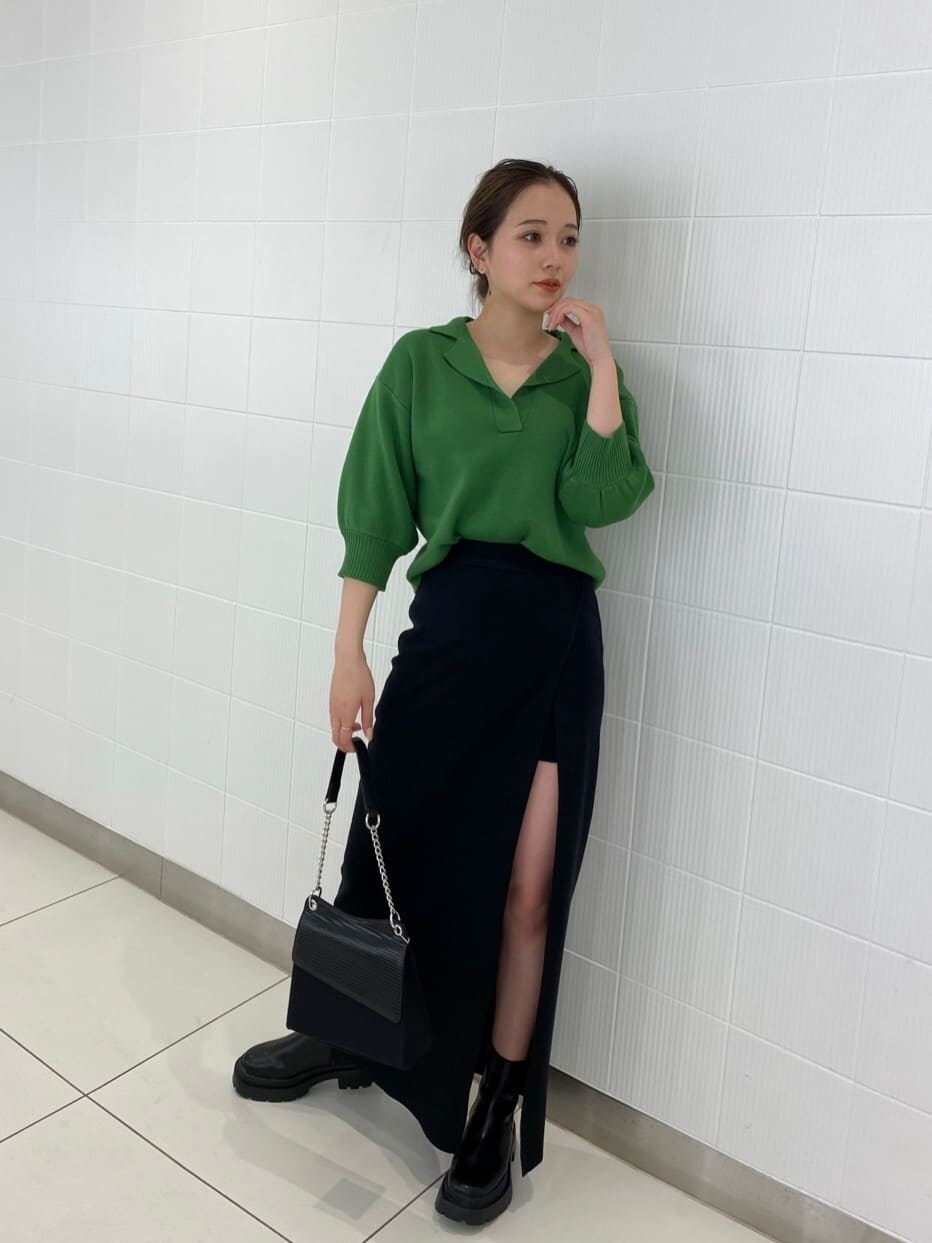 ブラック系のブーツ、ブラック系のハンドバッグ、ブラック系のスカートを着用したレディースの春コーディネートの2枚目の写真