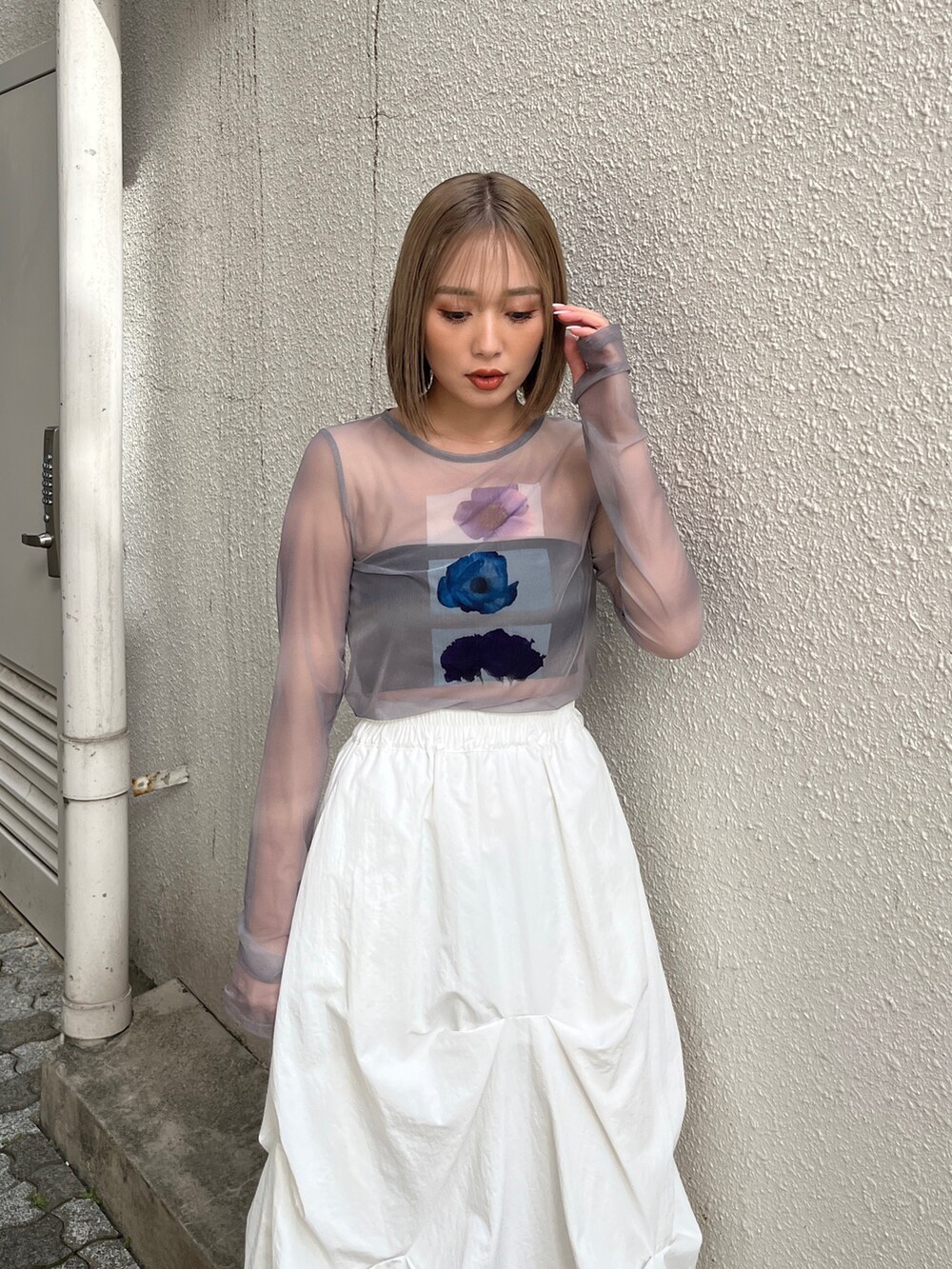 グレー系のTシャツ/カットソー、ホワイト系のベスト、ホワイト系のスカートを着用したレディースの冬コーディネートの10枚目の写真
