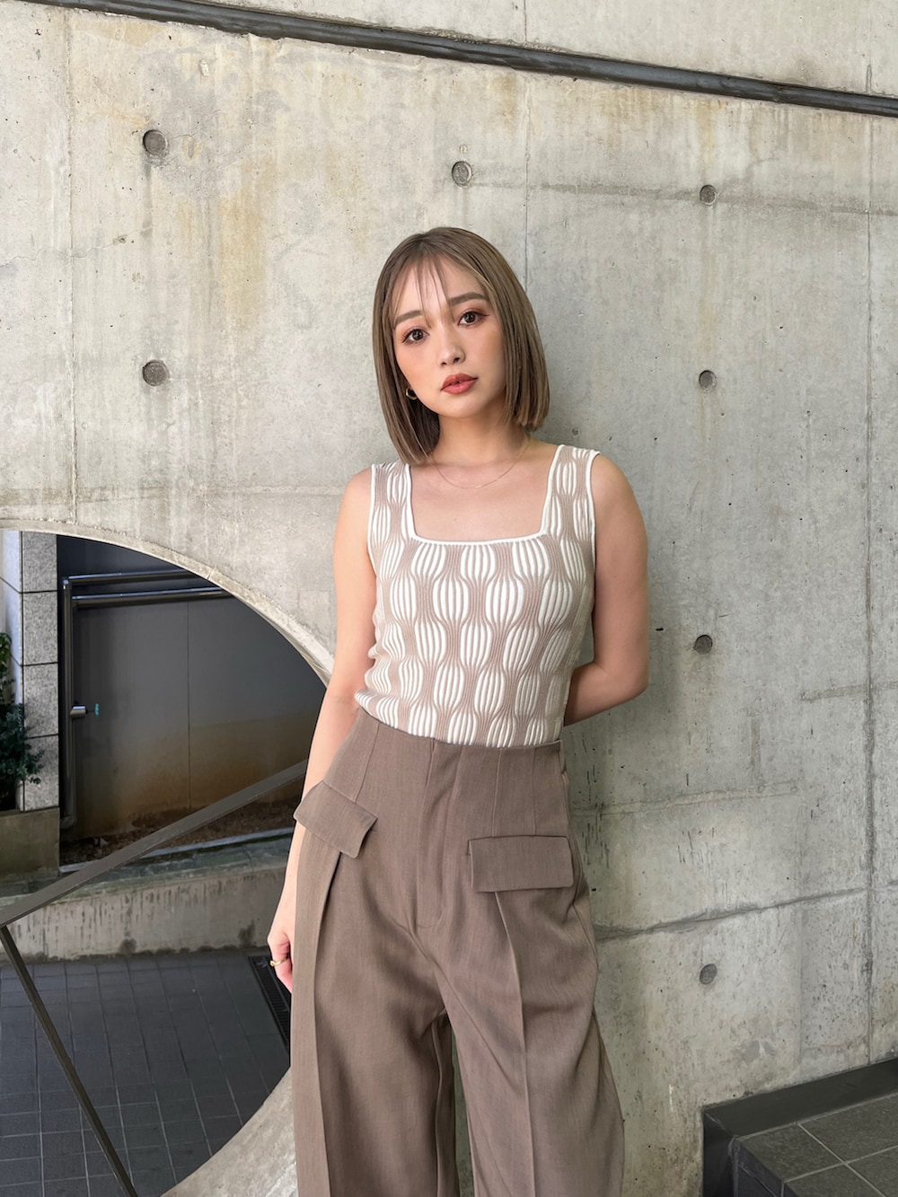 ブラウン系のベスト、ホワイト系のタンクトップ、ブラウン系のその他パンツを着用したレディースの夏コーディネートの6枚目の写真