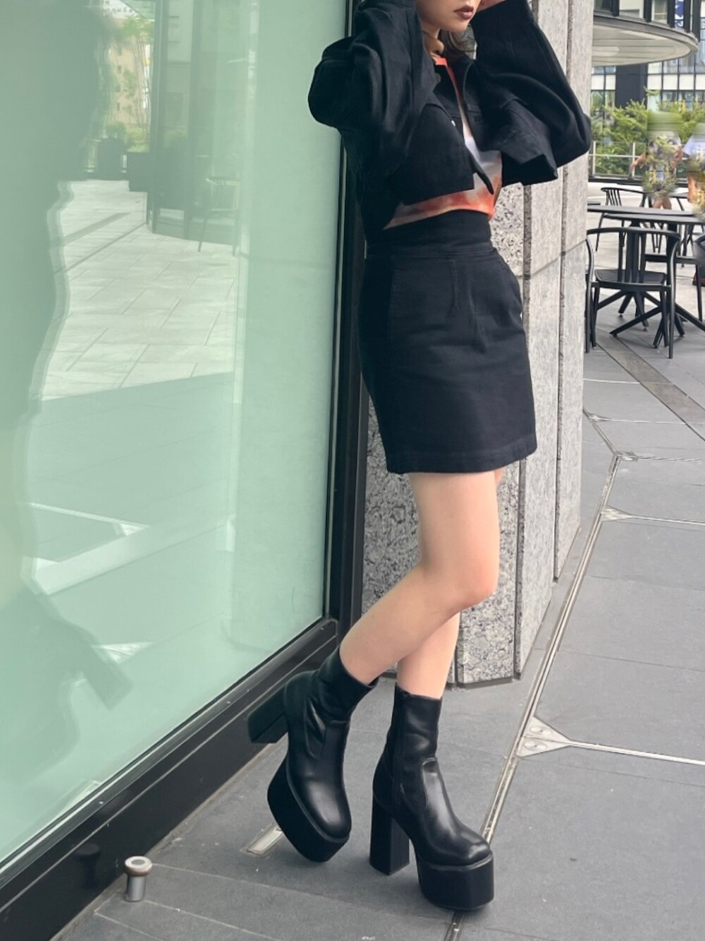 オレンジ系のTシャツ/カットソー、ブラック系のデニムジャケット、ブラック系のスカートを着用したレディースの夏コーディネートの4枚目の写真