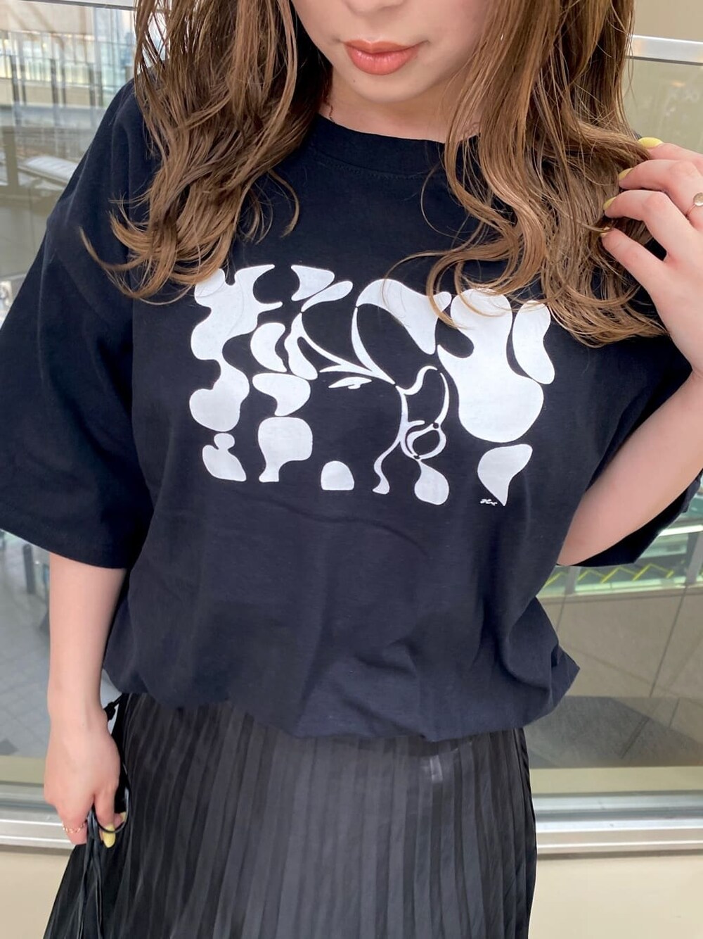 ブラック系のスカート、ブラック系のハンドバッグ、ブラック系のTシャツ/カットソーを着用したレディースの春コーディネートの5枚目の写真