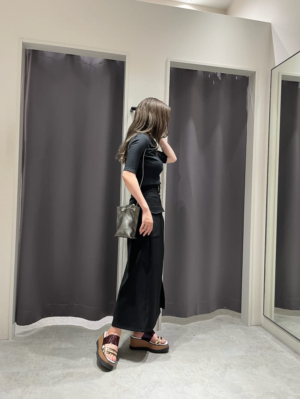 ブラック系のスカート、その他のサンダル、ブラック系のショルダーバッグを着用したレディースの夏コーディネートの2枚目の写真