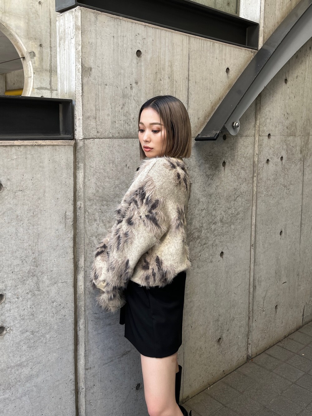 ホワイト系のニット/セーター、ブラック系のブーツを着用したレディースの秋コーディネートの9枚目の写真