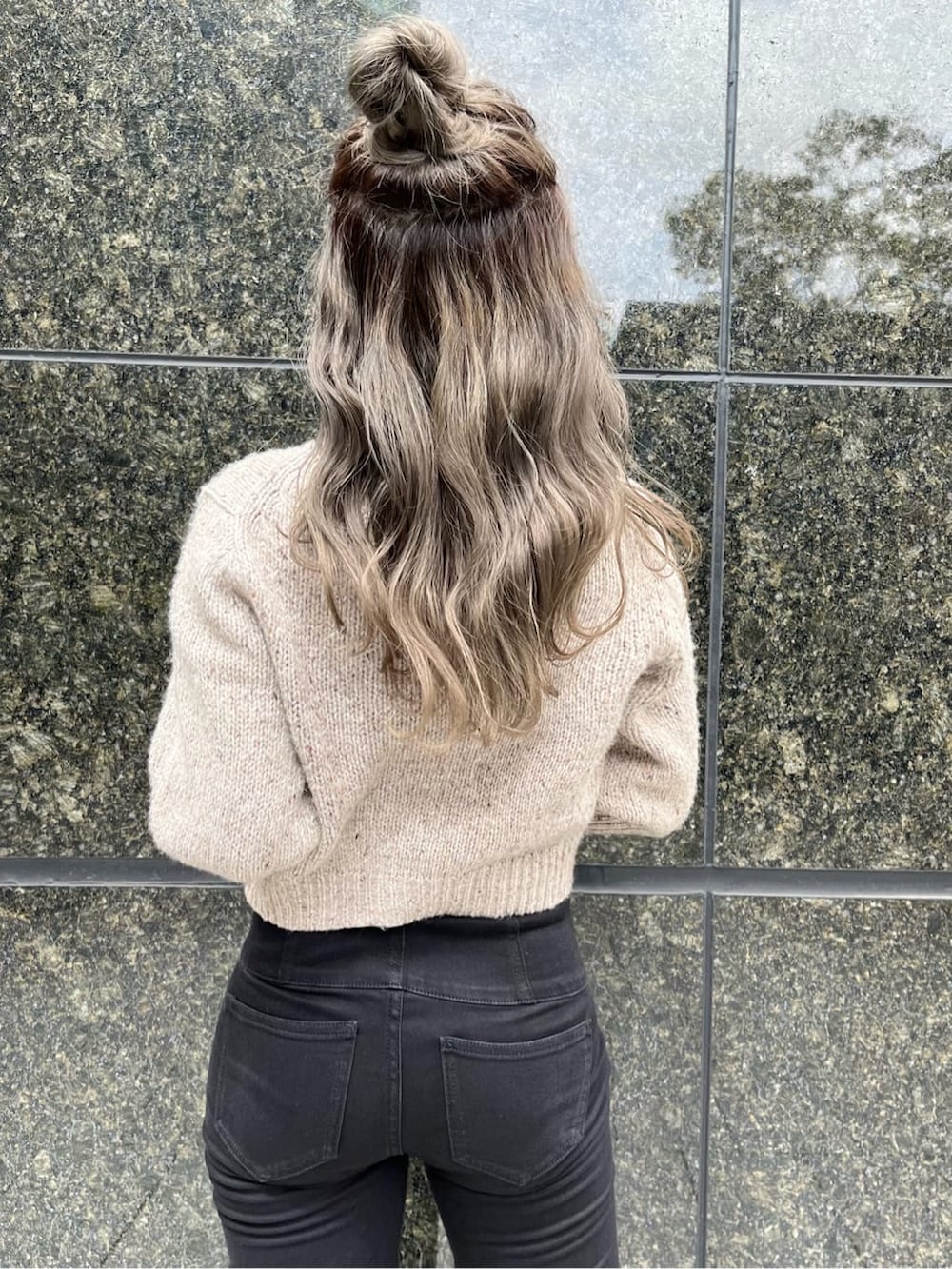 ブラック系のデニムパンツ、ブラック系のブーツ、ホワイト系のニット/セーターを着用したレディースの秋コーディネートの4枚目の写真