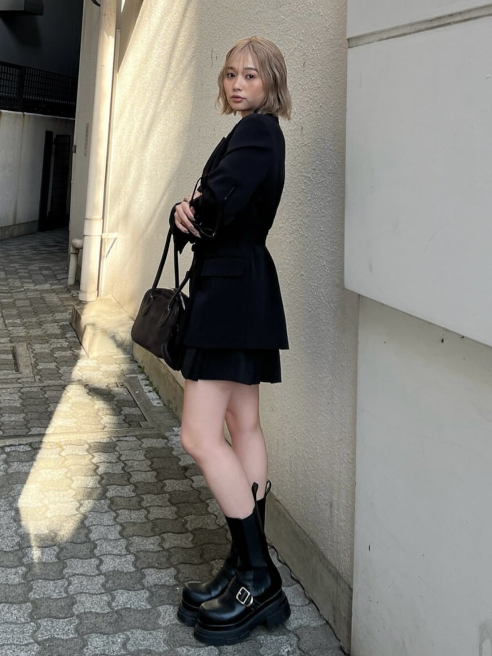 ブラック系のブーツ、ブラック系のテーラードジャケット、ブラウン系のキャミソールを着用したレディースの春コーディネートの5枚目の写真