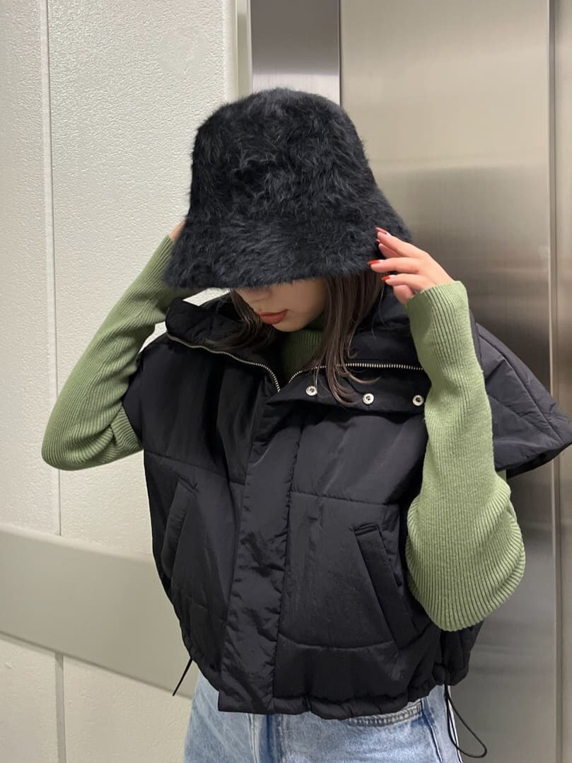 ブラック系のダウンベスト、グリーン系のニット/セーター、ブラック系のハットを着用したレディースの秋コーディネートの7枚目の写真