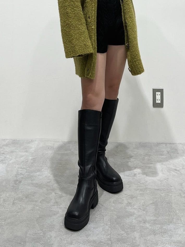 ブラック系のニット/セーター、ブラック系のブーツ、ブラック系のスウェットパンツを着用したレディースの秋コーディネートの8枚目の写真