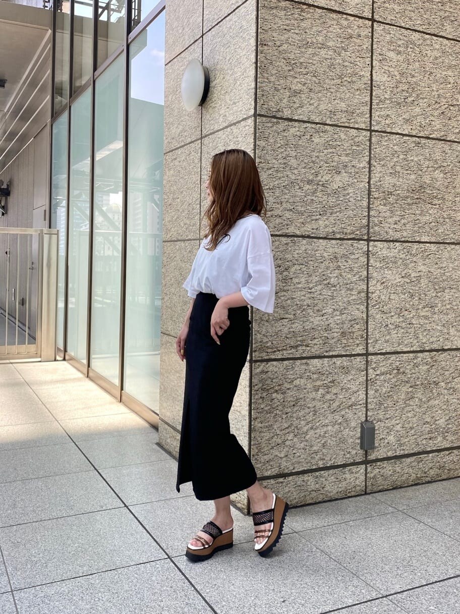 ブラック系のスカート、ホワイト系のTシャツ/カットソー、その他のサンダルを着用したレディースの春コーディネートの4枚目の写真