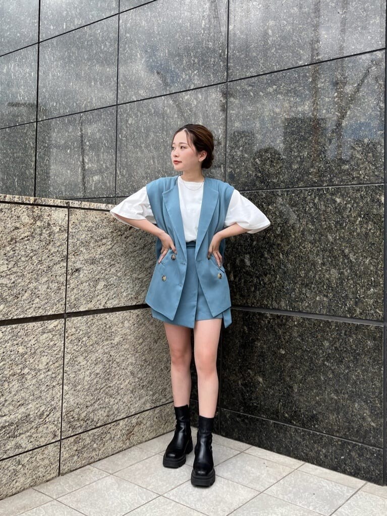 ホワイト系のTシャツ/カットソー、ブルー系のベスト、ブルー系のスラックスを着用したレディースの夏コーディネートの2枚目の写真