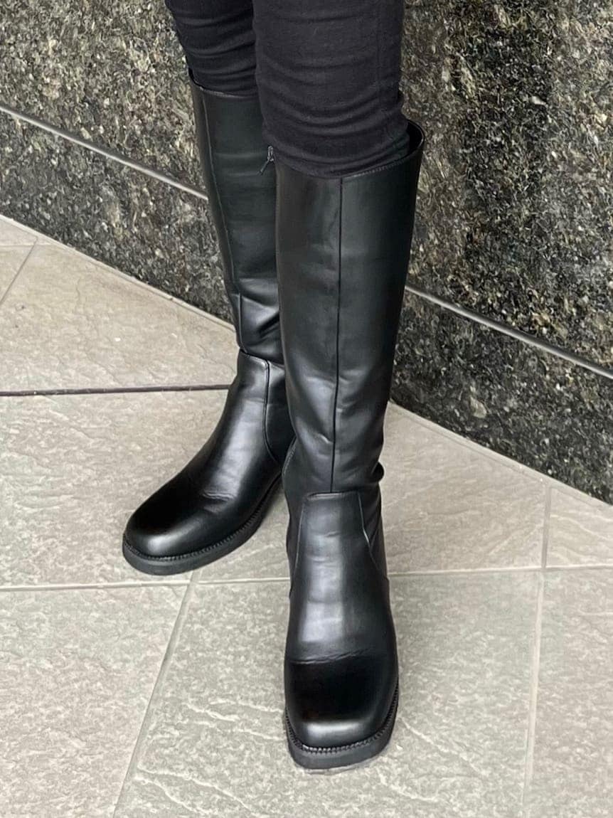 ブラック系のデニムパンツ、ブラック系のブーツ、ホワイト系のニット/セーターを着用したレディースの秋コーディネートの7枚目の写真