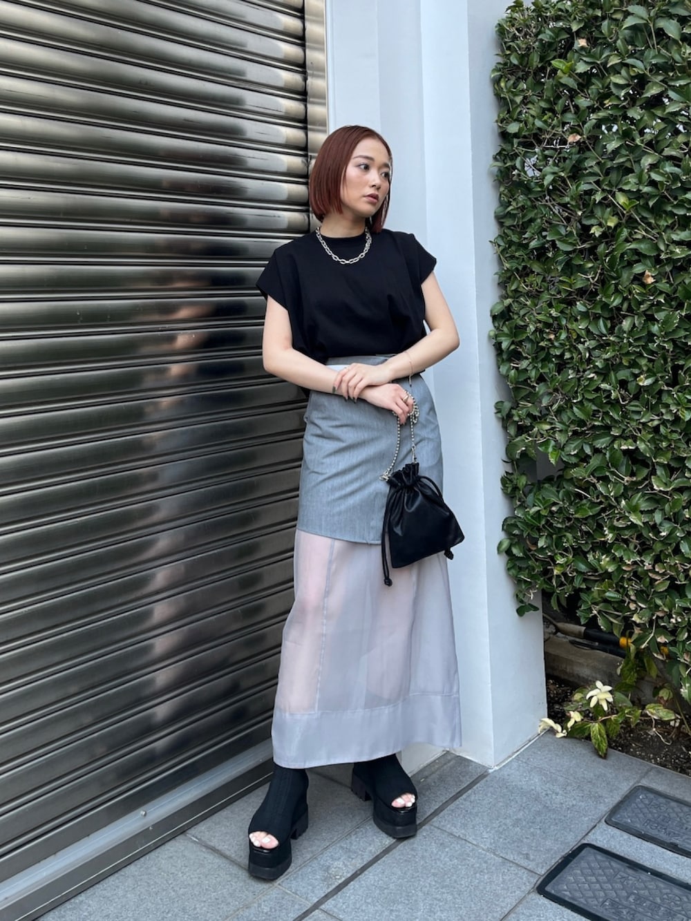 ブラック系のTシャツ/カットソー、グレー系のスカート、ブラック系のブーツを着用したレディースの夏コーディネートの2枚目の写真