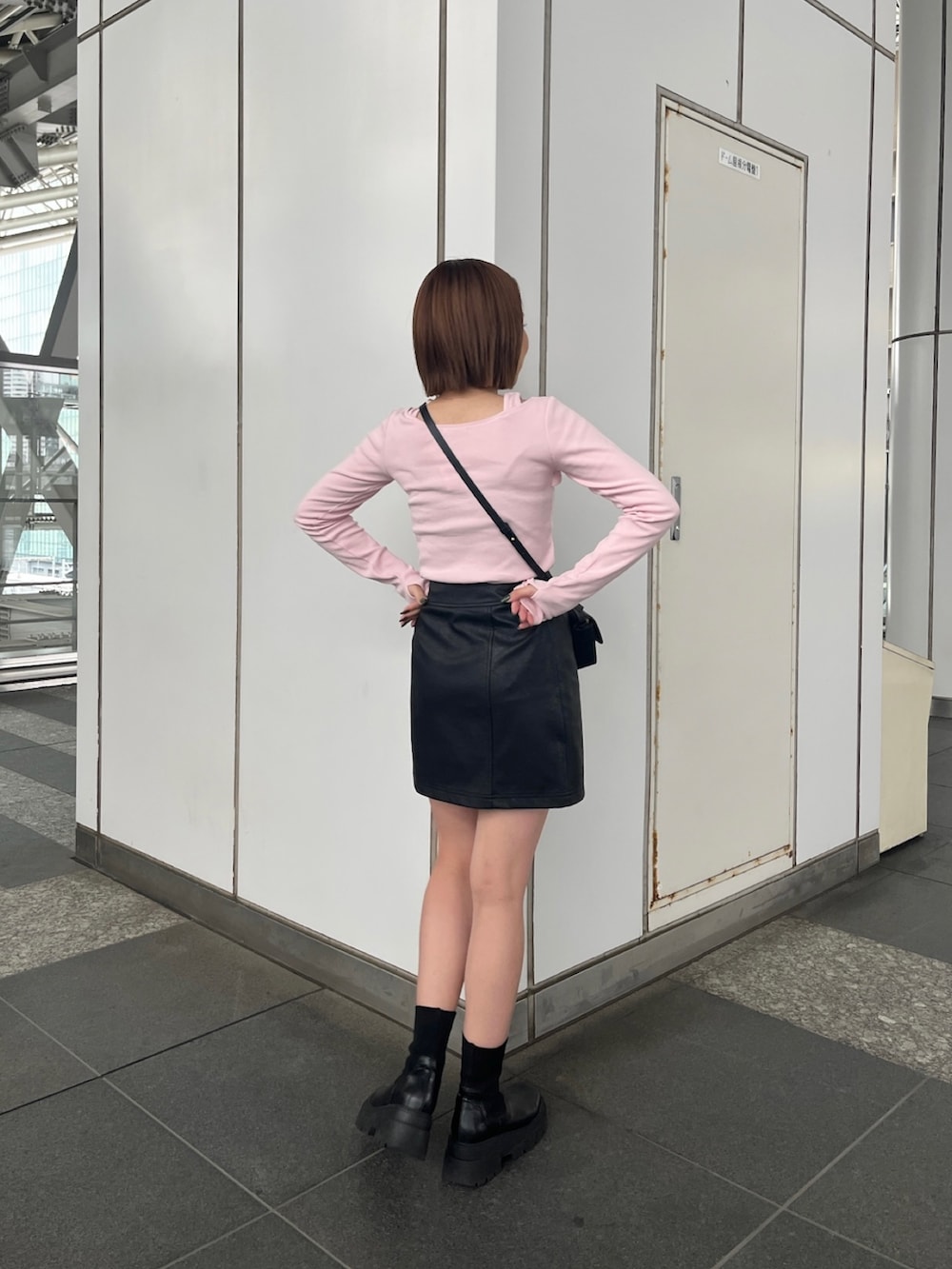 ピンク系のTシャツ/カットソー、ブラック系のスカートを着用したレディースの冬コーディネートの2枚目の写真