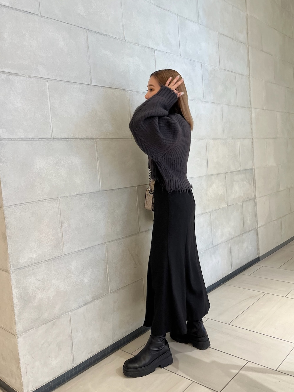 グレー系のニット/セーター、その他のショルダーバッグ、ブラック系のスカートを着用したレディースの秋コーディネートの3枚目の写真