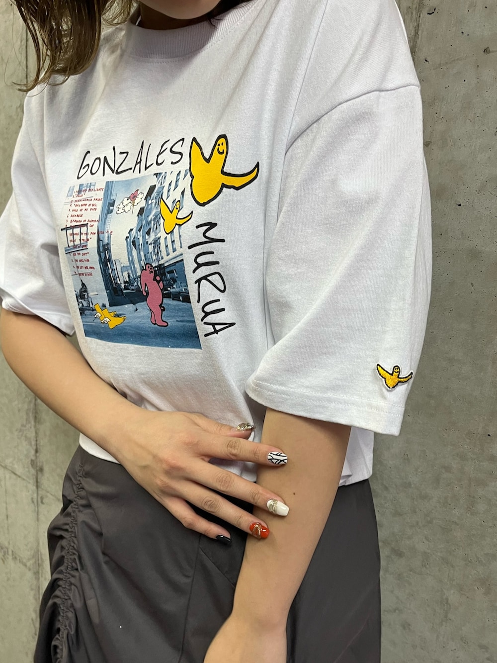 ブラック系のサンダル、ホワイト系のTシャツ/カットソー、グレー系のスカートを着用したレディースの春コーディネートの4枚目の写真