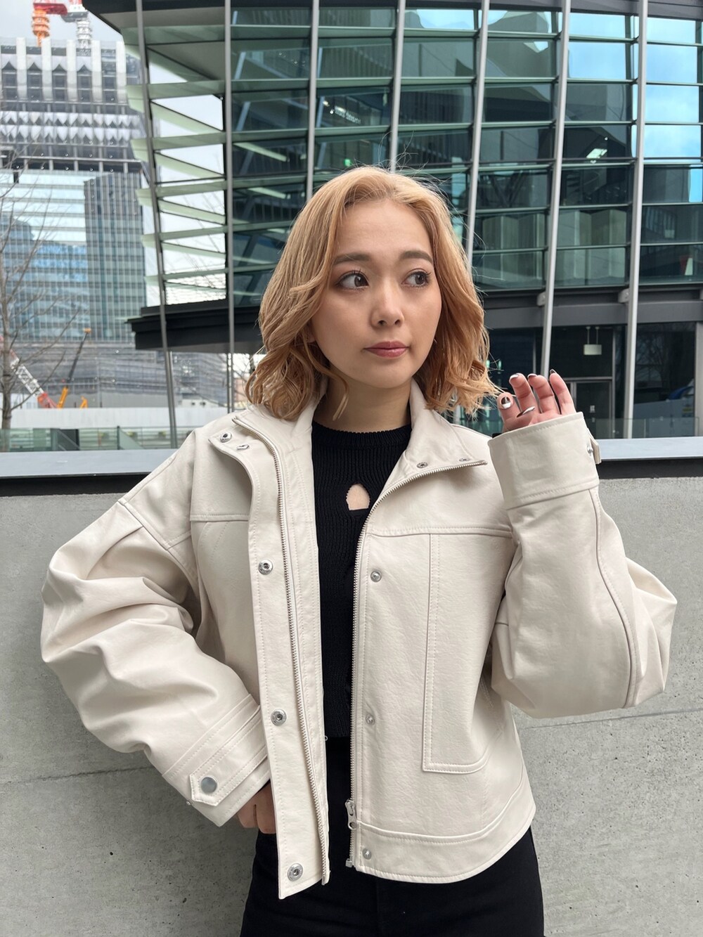 ホワイト系のブルゾン、ブラック系のニット/セーター、ブラック系のデニムパンツを着用したレディースの冬コーディネートの6枚目の写真