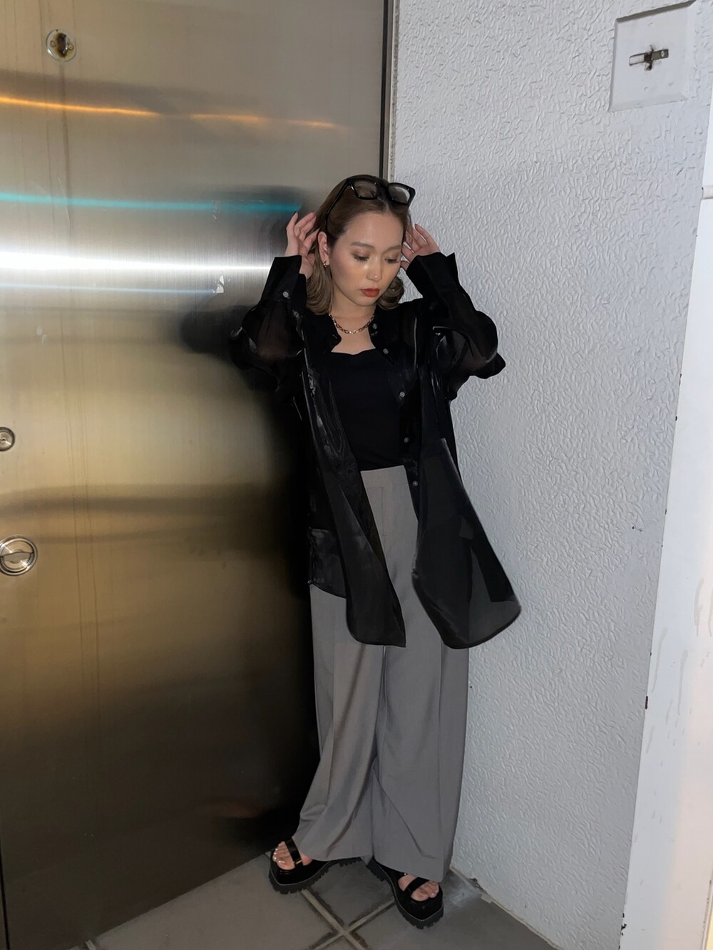 ブラック系のシャツ/ブラウス、グレー系のスラックス、ブラック系のサンダルを着用したレディースの春コーディネートの2枚目の写真