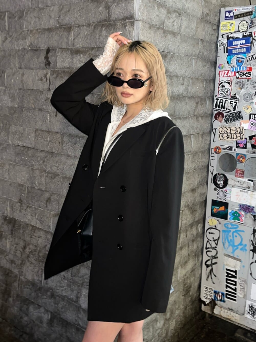 ブラック系のブーツ、ホワイト系のパーカー、ブラック系のテーラードジャケットを着用したレディースの春コーディネートの6枚目の写真