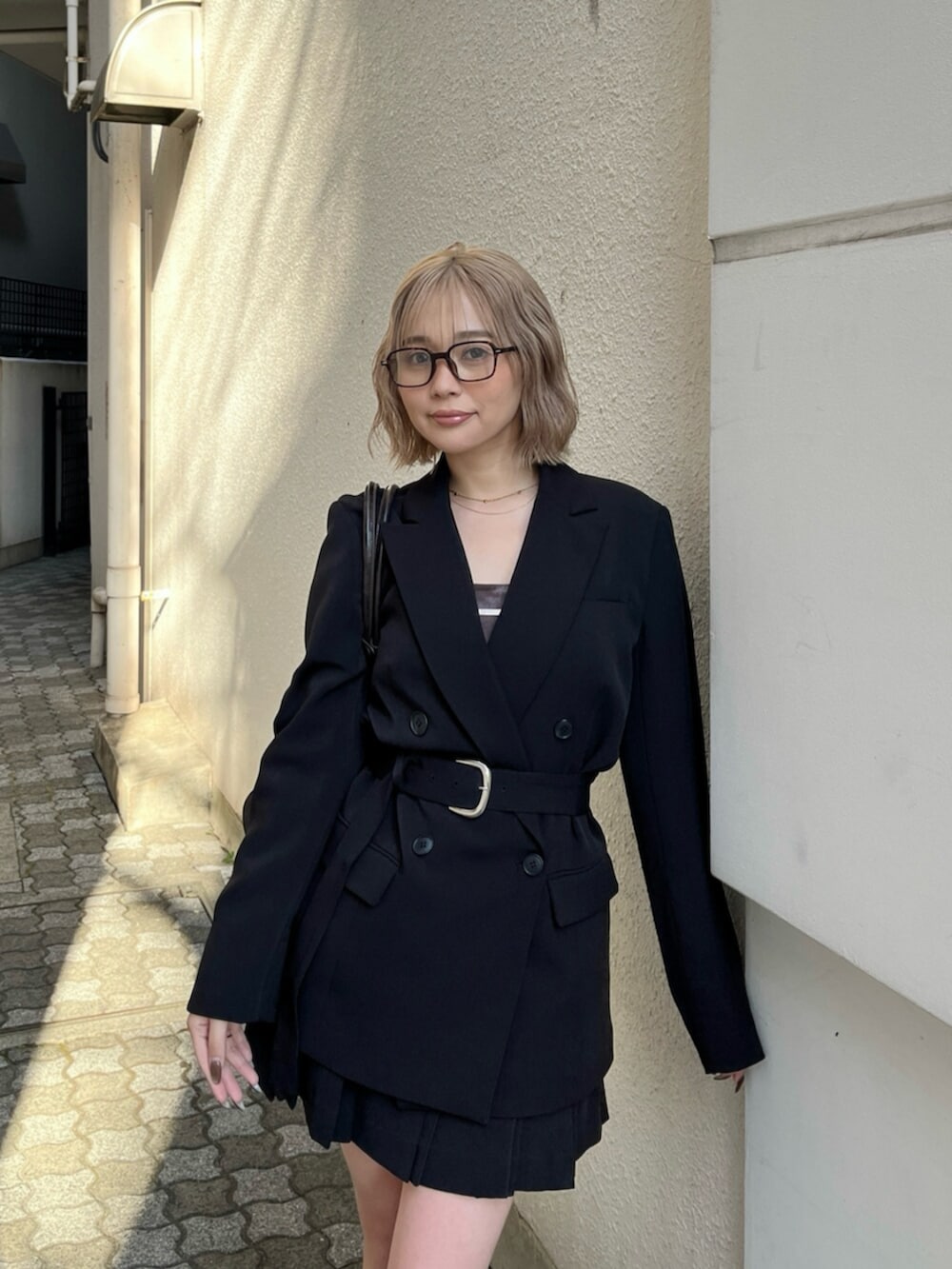 ブラック系のブーツ、ブラック系のテーラードジャケット、ブラウン系のキャミソールを着用したレディースの春コーディネートの7枚目の写真