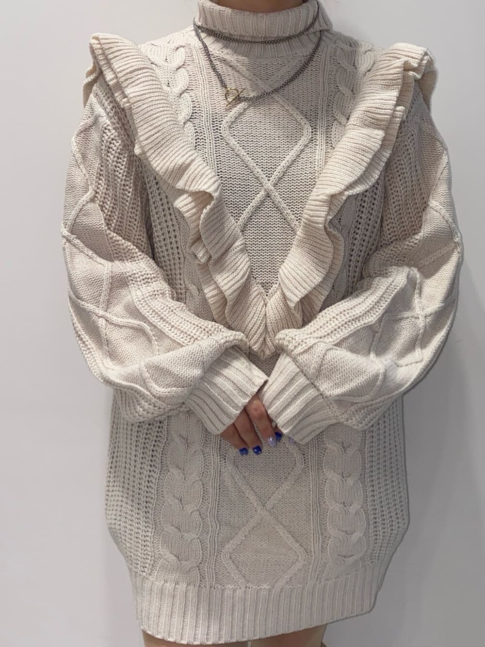 ホワイト系のニット/セーター、ホワイト系のブーツを着用したレディースの秋コーディネートの4枚目の写真