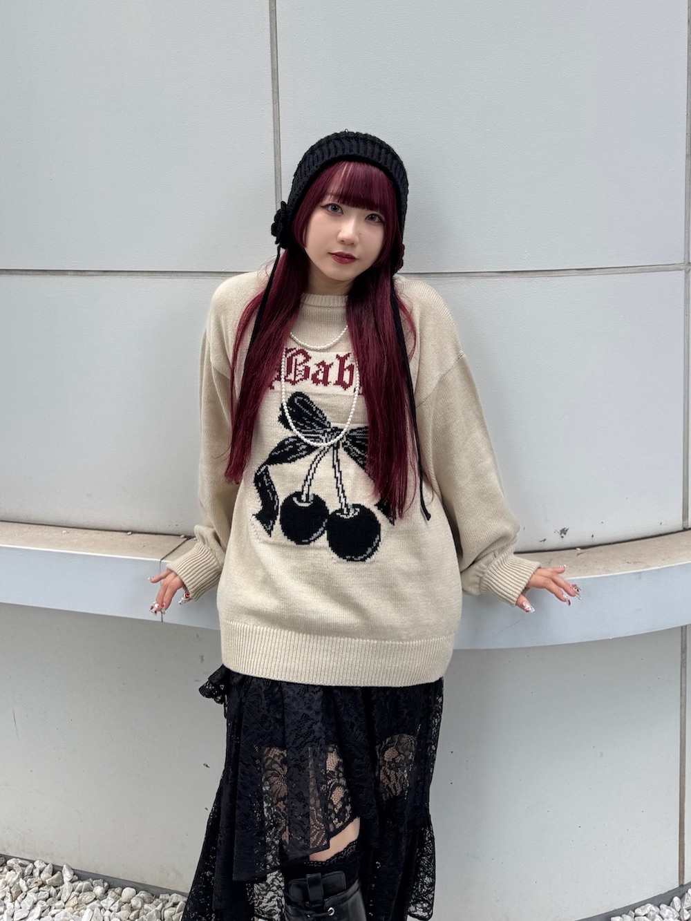 ホワイト系のニット/セーター、ブラック系のスカート、ブラック系のニットキャップ/ビーニーを着用したレディースの夏コーディネートの2枚目の写真