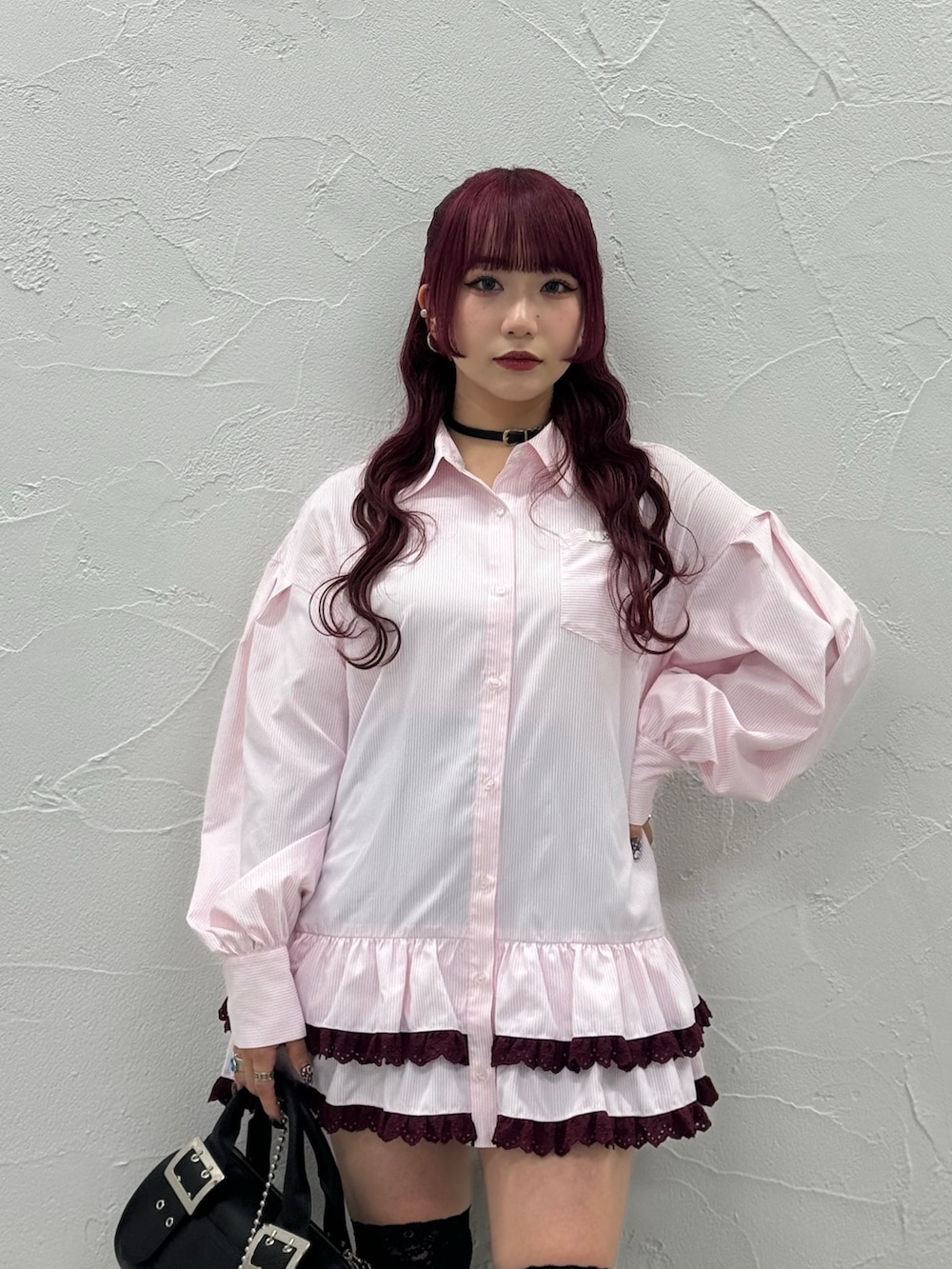 ピンク系のシャツ/ブラウス、ブラック系のボストンバッグ、ブラック系のブーツを着用したレディースの秋コーディネートの3枚目の写真