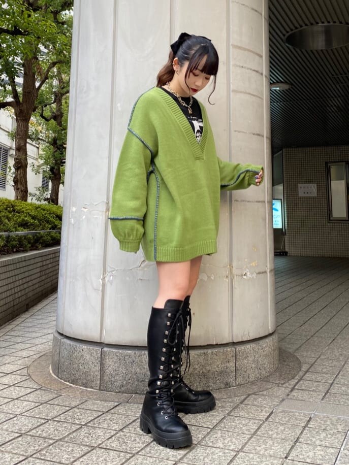 ブラック系のブーツ、グリーン系のニット/セーター、ブラック系のTシャツ/カットソーを着用したレディースの冬コーディネートの2枚目の写真