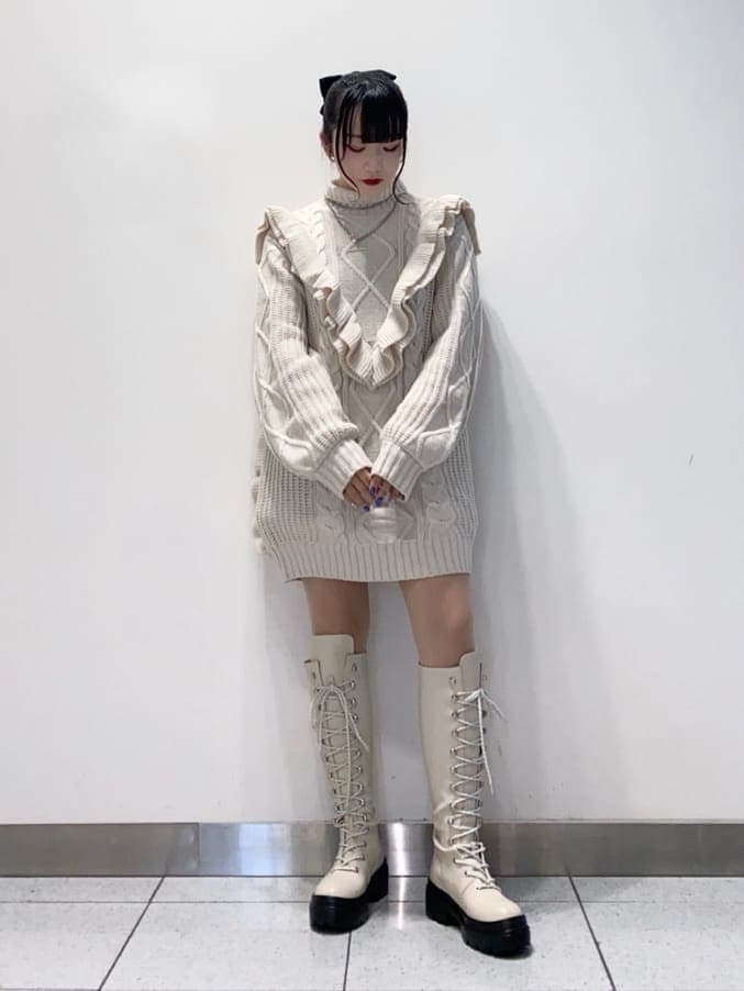 ホワイト系のニット/セーター、ホワイト系のブーツを着用したレディースの秋コーディネートの2枚目の写真