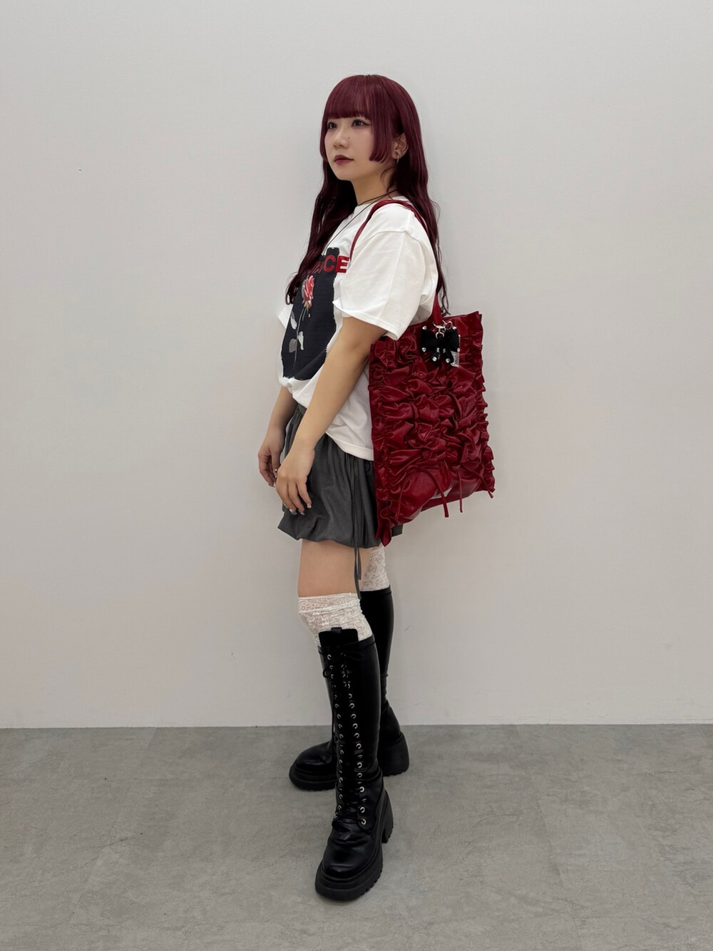 ホワイト系のTシャツ/カットソー、グレー系のスカート、レッド系のトートバッグを着用したレディースの春コーディネートの2枚目の写真