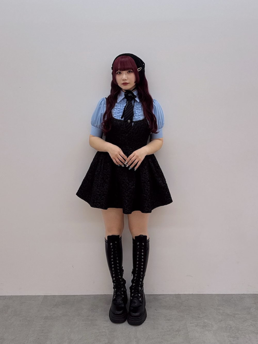 ブラック系のネクタイ、ブラック系のチュニック、ブルー系のシャツ/ブラウスを着用したレディースの春コーディネートの2枚目の写真