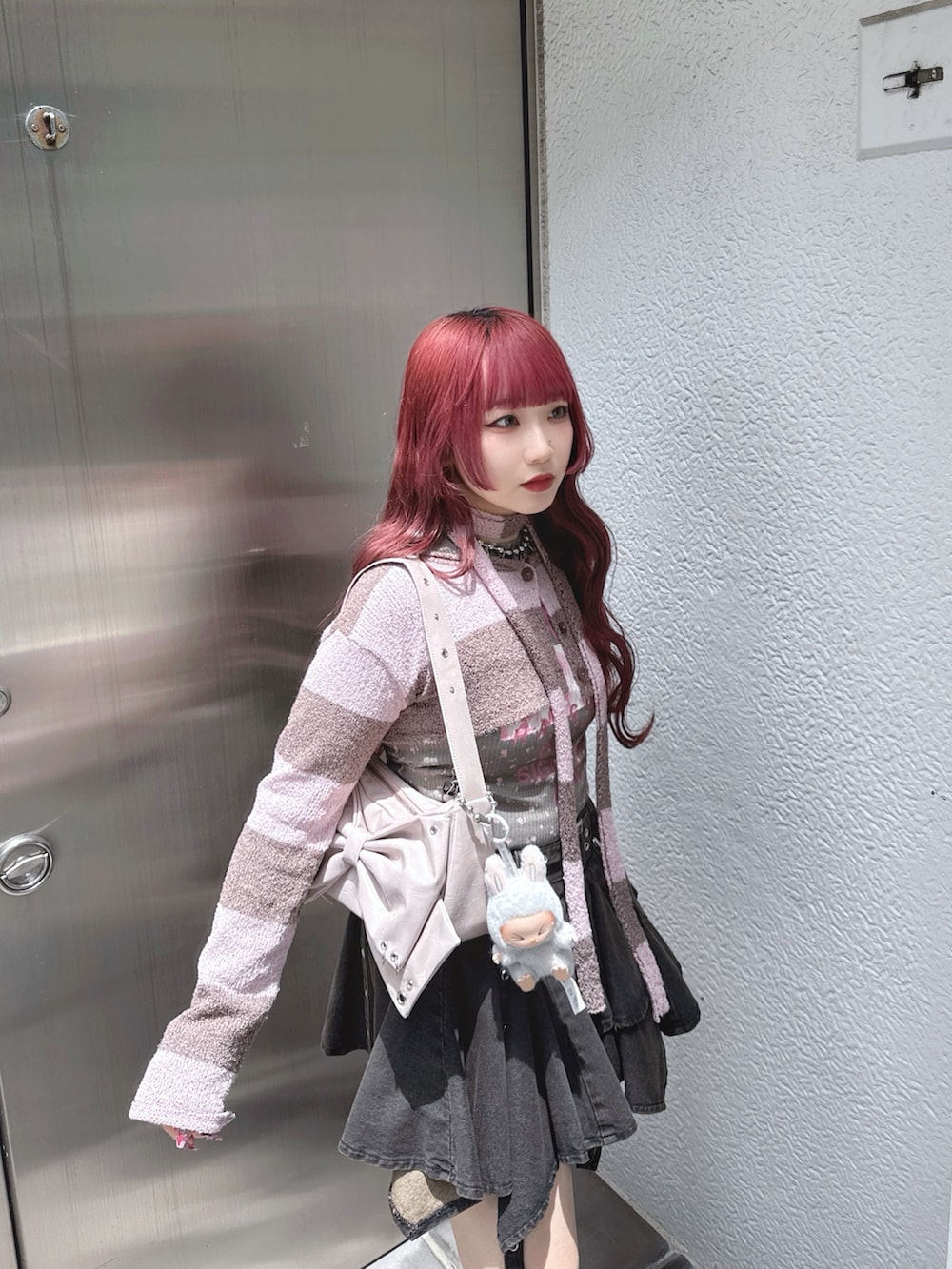 ブラック系のデニムスカート、ピンク系のカーディガン/ボレロ、グリーン系のTシャツ/カットソーを着用したレディースの夏コーディネートの2枚目の写真