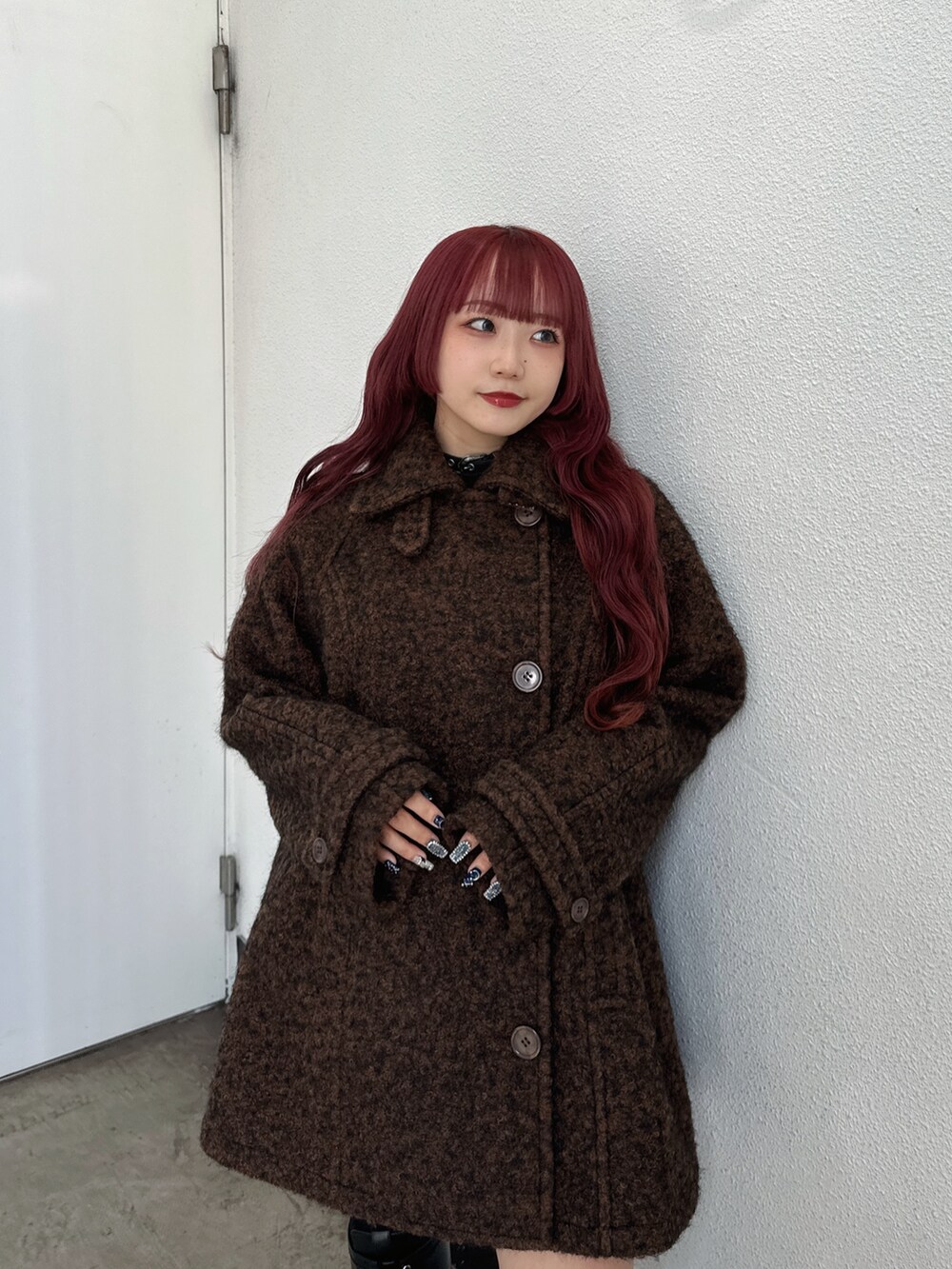 ブラウン系のステンカラーコートを着用したレディースの秋コーディネートの3枚目の写真