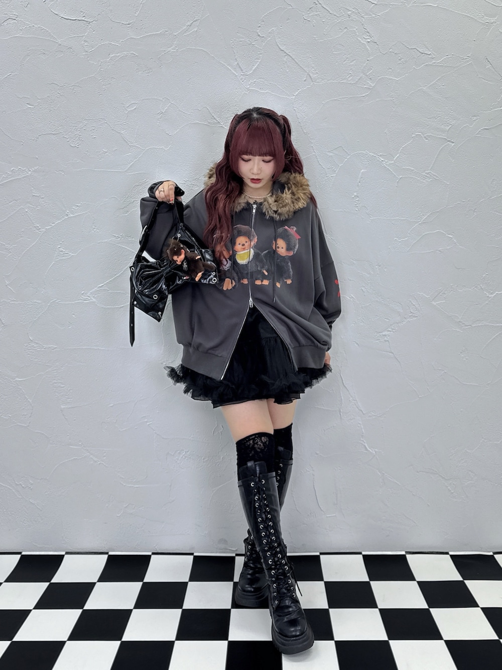 ブラック系のパーカー、ブラック系のスカート、ブラック系のショルダーバッグを着用したレディースの夏コーディネートの2枚目の写真