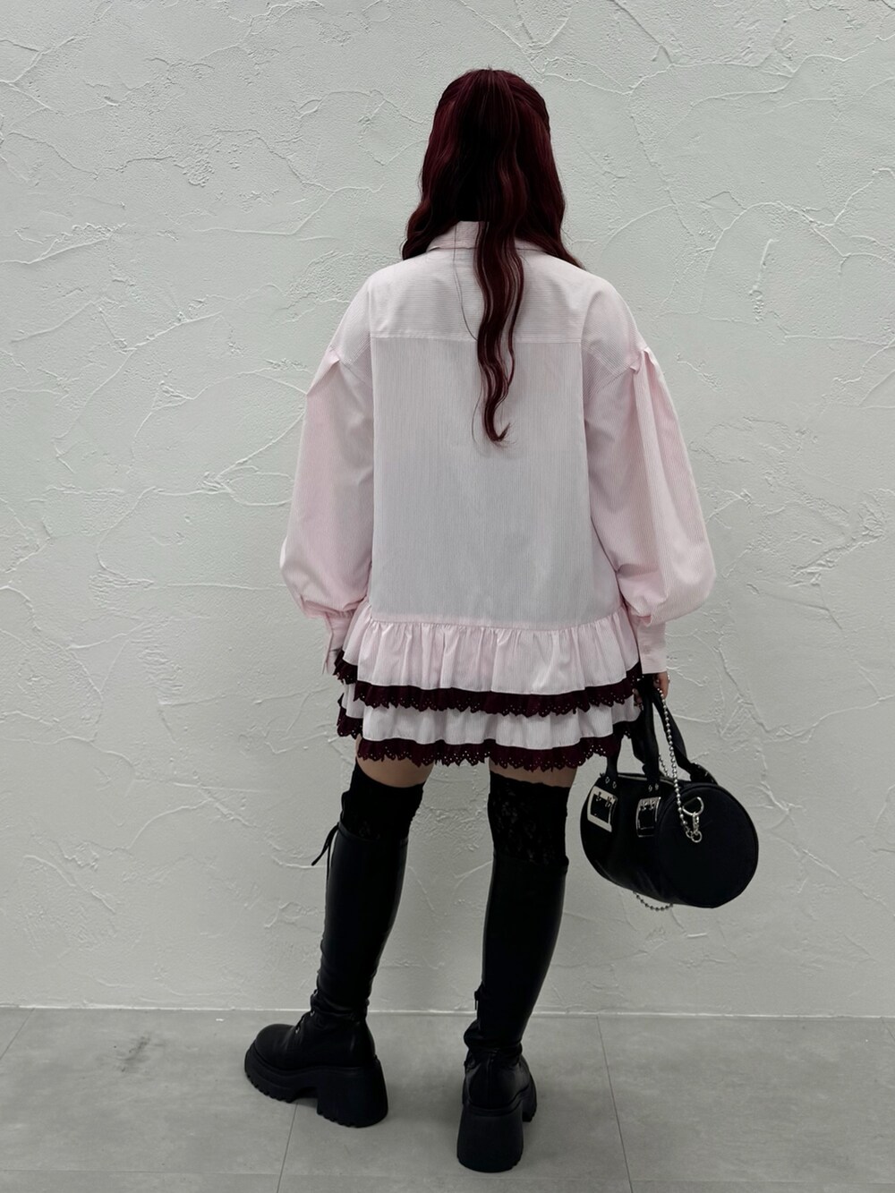 ピンク系のシャツ/ブラウス、ブラック系のボストンバッグ、ブラック系のブーツを着用したレディースの秋コーディネートの2枚目の写真