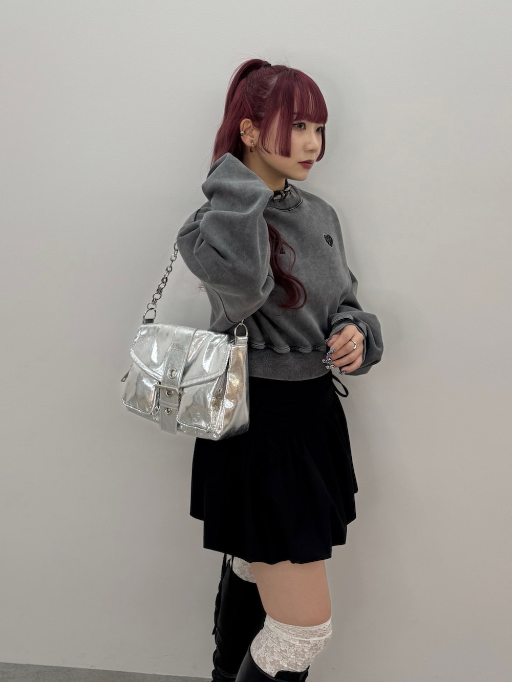 シルバー系のハンドバッグ、ブラック系のスウェットを着用したレディースの冬コーディネートの2枚目の写真