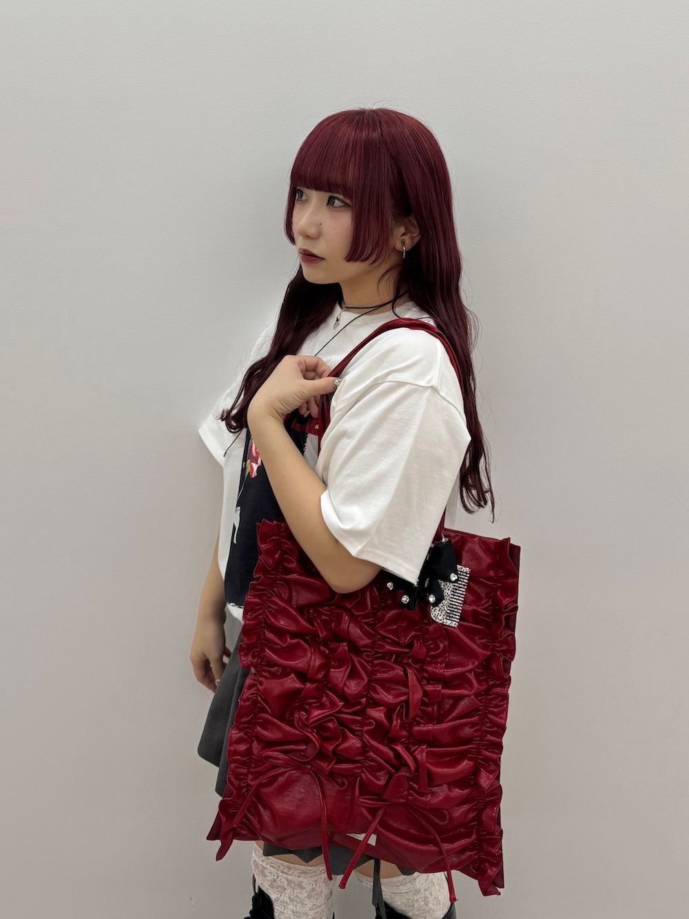 ホワイト系のTシャツ/カットソー、グレー系のスカート、レッド系のトートバッグを着用したレディースの春コーディネートの4枚目の写真