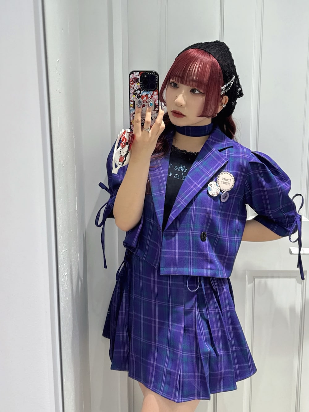 ブラック系のタンクトップ、ブラック系のブーツ、パープル系のスカートを着用したレディースの冬コーディネートの5枚目の写真