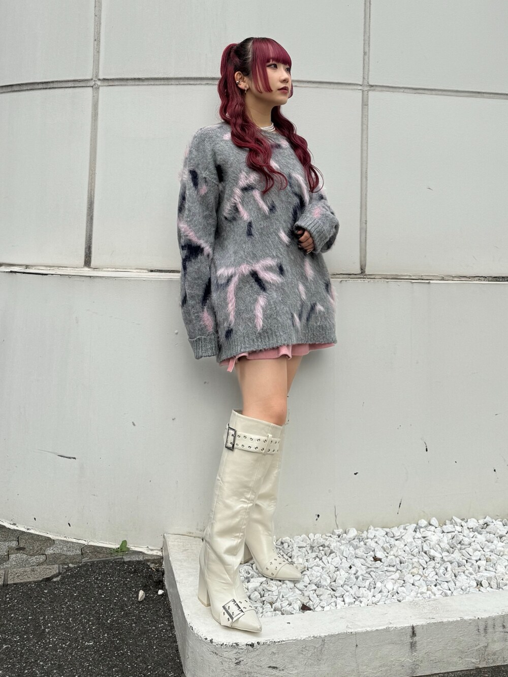 グレー系のニット/セーター、ピンク系のスカート、ホワイト系のブーツを着用したレディースの秋コーディネートの2枚目の写真