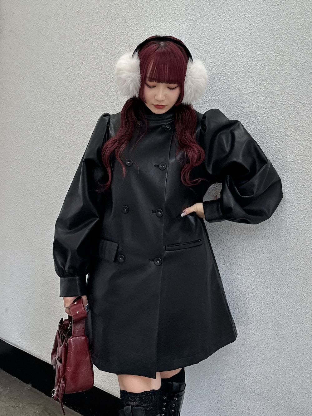 ブラック系のその他アウター、レッド系のショルダーバッグ、ホワイト系のイヤーマフを着用したレディースの秋コーディネートの3枚目の写真