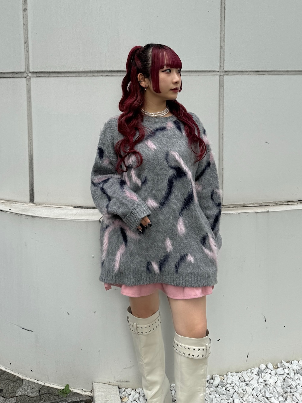 グレー系のニット/セーター、ピンク系のスカート、ホワイト系のブーツを着用したレディースの秋コーディネートの4枚目の写真