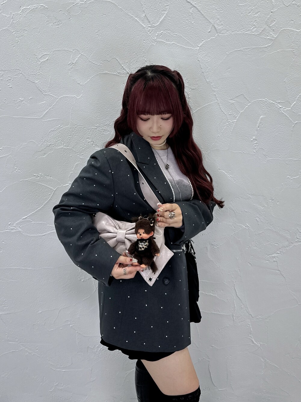 ピンク系のニット/セーター、グレー系のテーラードジャケット、ピンク系のショルダーバッグを着用したレディースの夏コーディネートの3枚目の写真