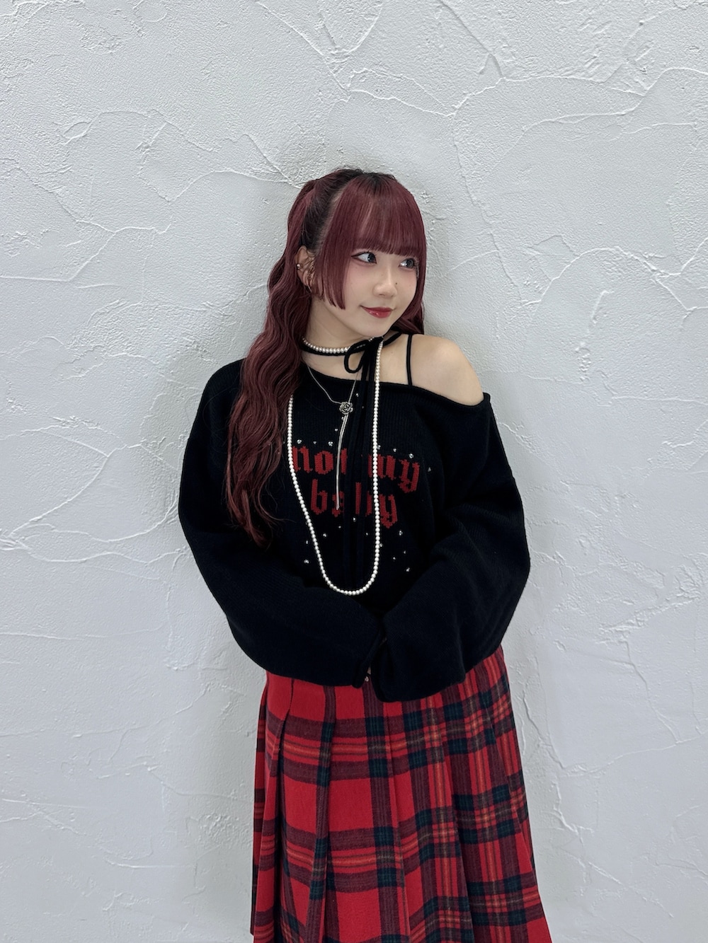 ブラック系のニット/セーター、レッド系のスカートを着用したレディースの秋コーディネートの4枚目の写真