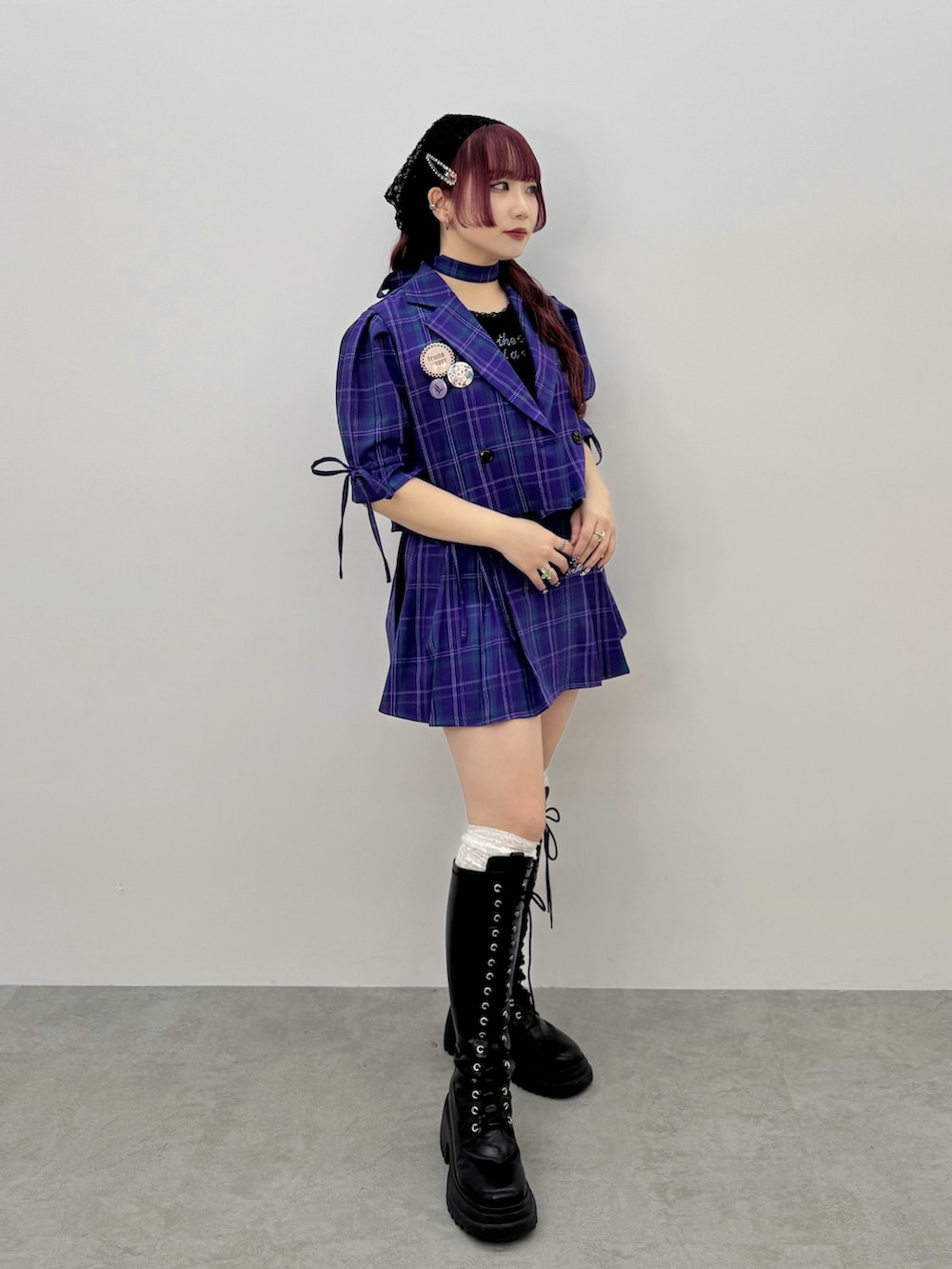 ブラック系のタンクトップ、ブラック系のブーツ、パープル系のスカートを着用したレディースの冬コーディネートの2枚目の写真