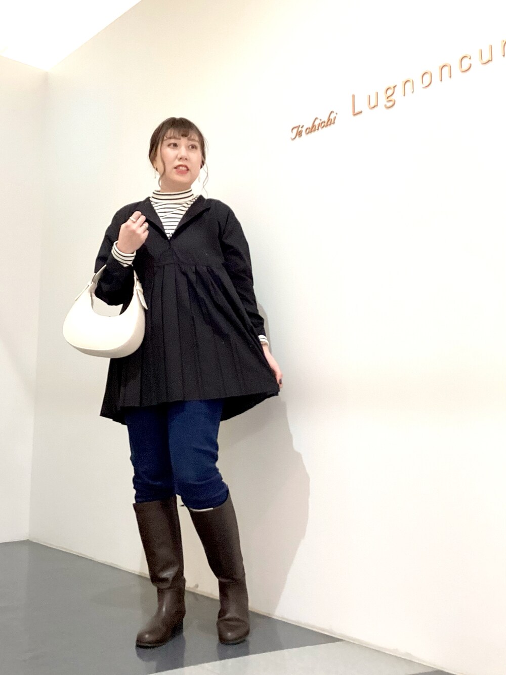 ブラック系のシャツ/ブラウス、ホワイト系のハンドバッグ、ホワイト系のニット/セーターを着用したレディースの秋コーディネートの2枚目の写真