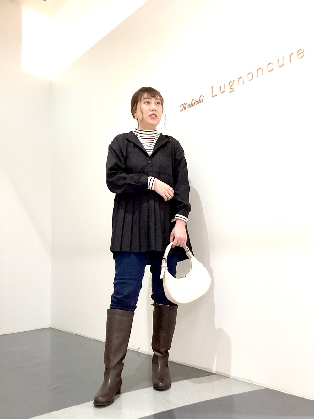 ブラック系のシャツ/ブラウス、ホワイト系のハンドバッグ、ホワイト系のニット/セーターを着用したレディースの秋コーディネートの3枚目の写真