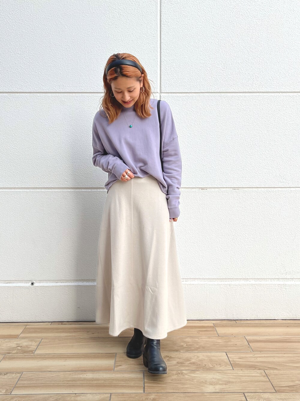 パープル系のスウェット、ブラック系のショルダーバッグ、ベージュ系のスカートを着用したレディースの秋コーディネートの2枚目の写真